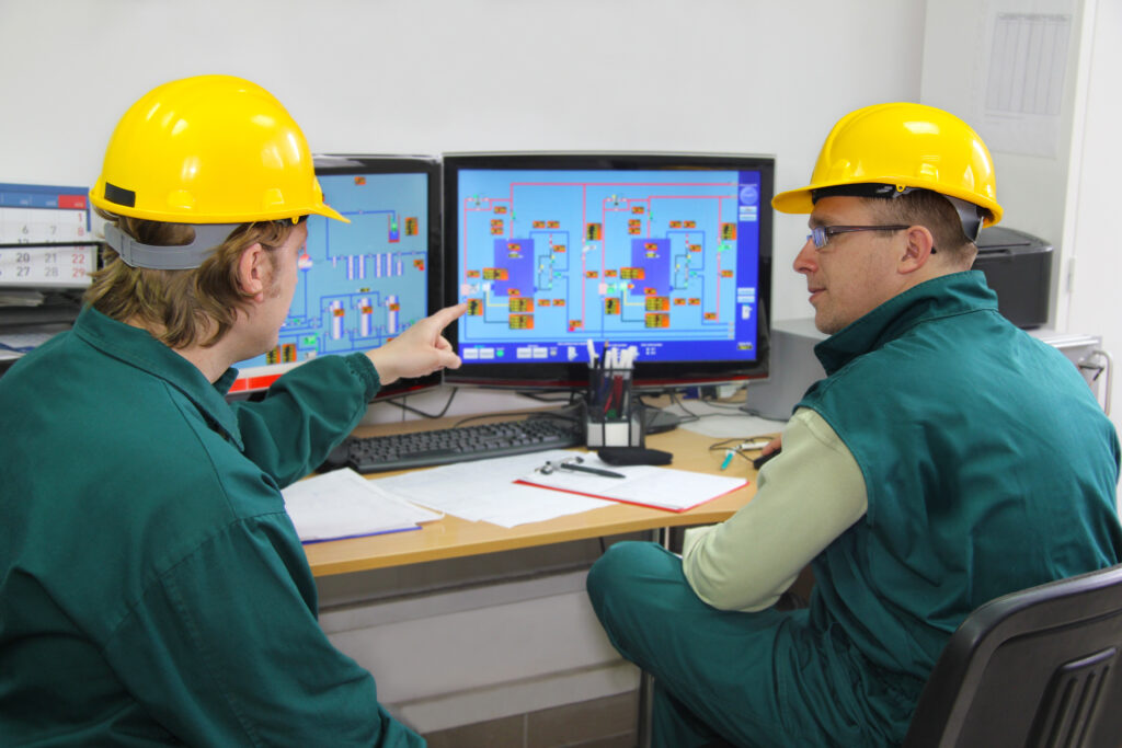 Industrial workers in control room Industrial workers in control room